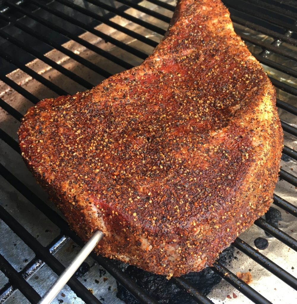 seasoned ribeye steak with temperature probe in a bbq